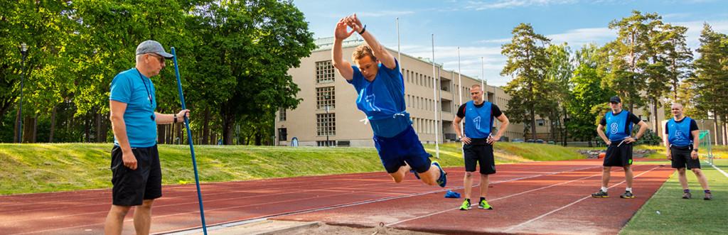 Reserviläinen hyppää vauhditonta pituutta urheilukentällä.