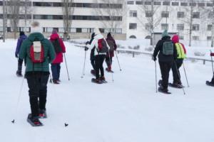ryhmä naisia koekävelee lumikenkien kanssa ennen metsäkävelylle lähtemistä