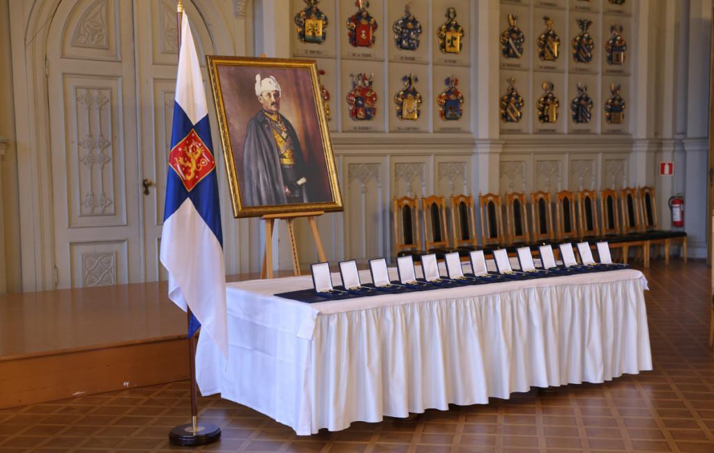 Vapaudenristin ritarikunnan kunniamerkit pöydällä Suomen lipun ja Mannerheimin muotokuvan vieressä.