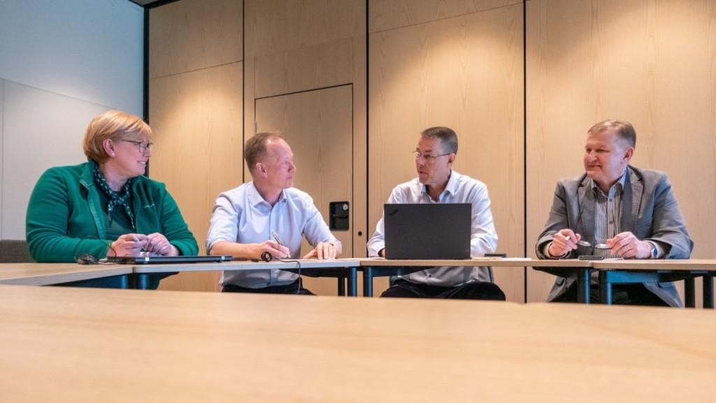 MPK:n työvaliokunnan Anne-May Asplund, Mika Hannula, Timo Niiranen ja Antti Lehtisalo istuvat pöydän ääressä.