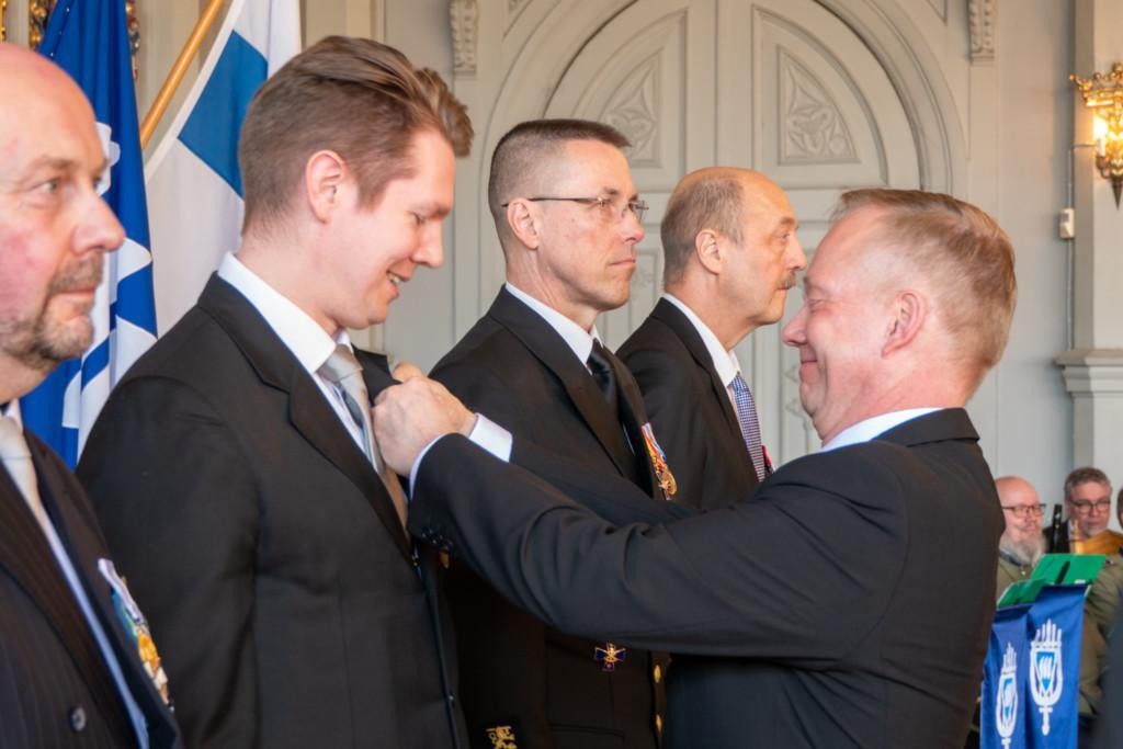 MPK:n puheenjohtaja kiinnittää Aaro Mäkelälle kultaisen ansiomitalin. Kuvassa myös muut palkitut Markus Lassheikki, Timo Niiranen ja Ismo Nöjd 