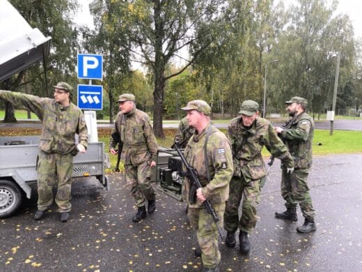 Ryhmä sotilaspukuisia ihmisiä parkkipaikalla
