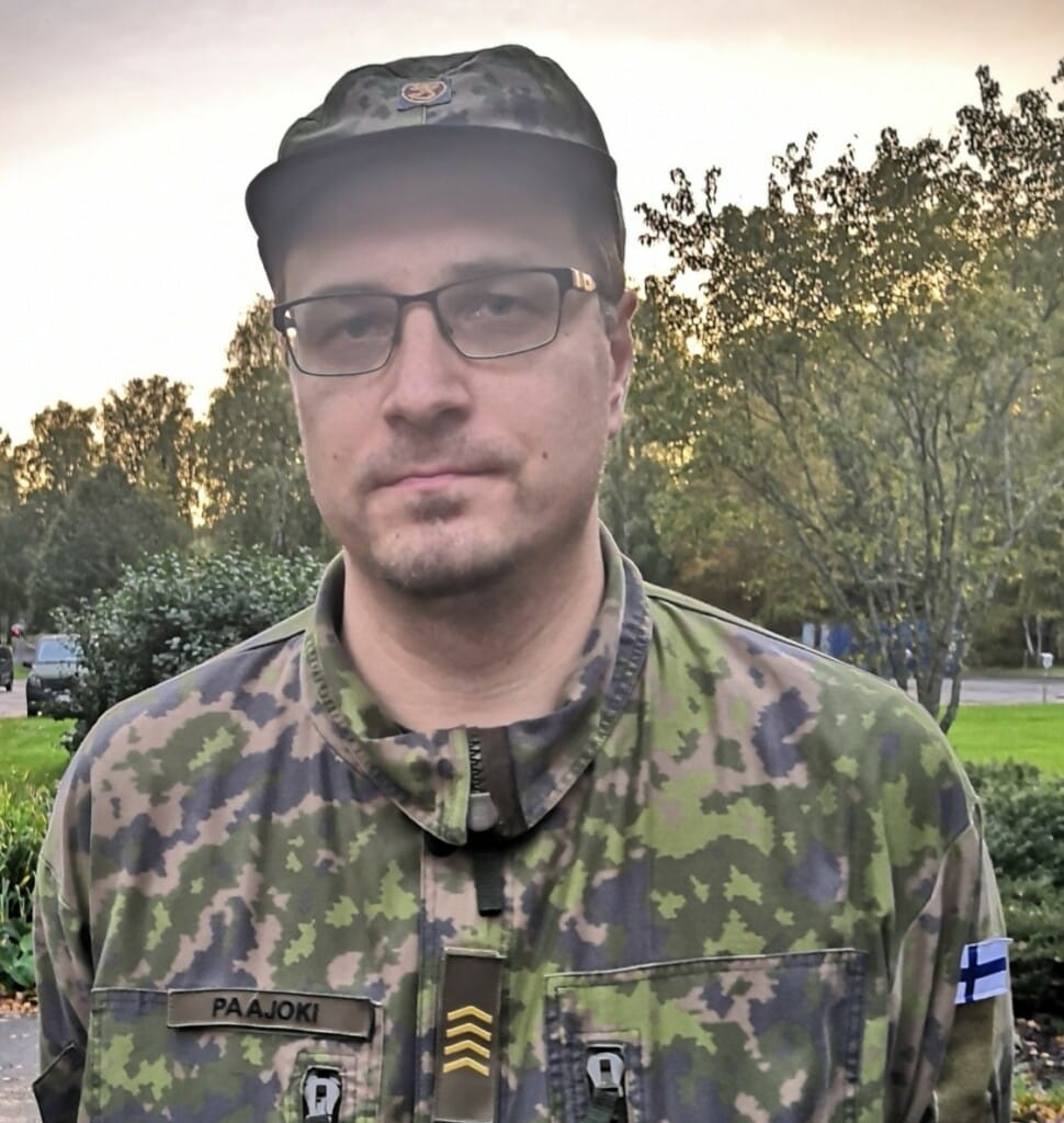 sotilaspukuinen mies katsoo kameraan