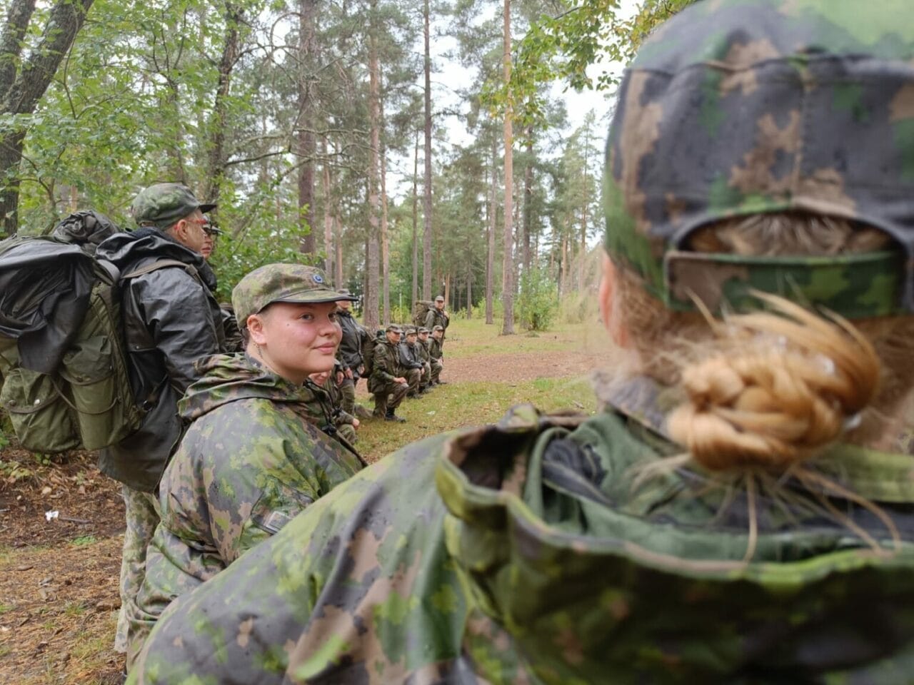 Ryhmä maastoasuisia henkilöitä metsässä