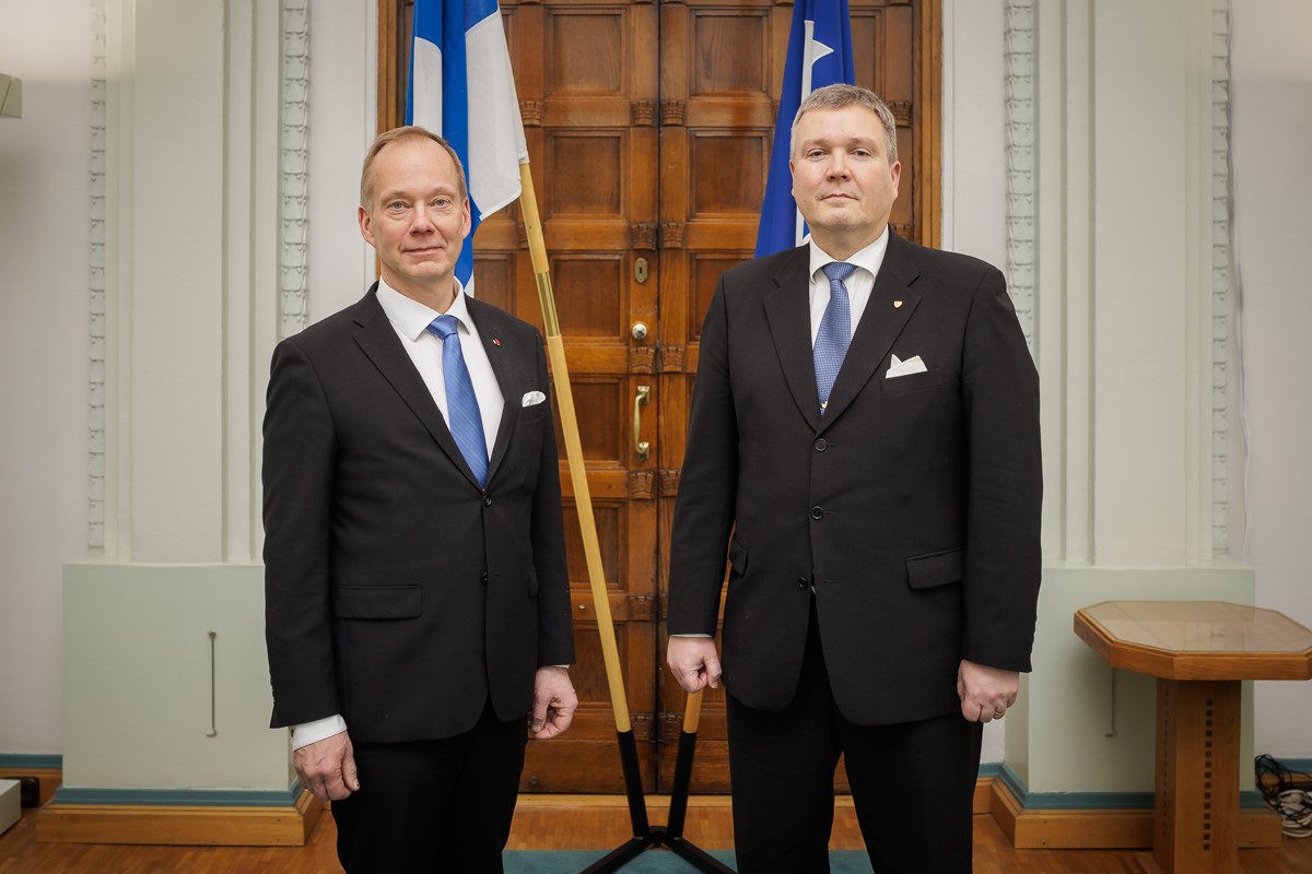 Mika Hannula ja Juha Parkkonen seisomassa Suomen lipun ja MPK:n lipun edessä