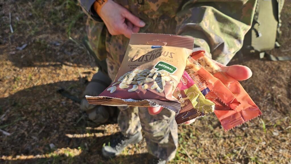 Kuvassa Jaana näyttää kurssille tuomansa cashew-pähkinäpussinsa sekä kolme muuta pähkinöitä sisältävää patukkaa.