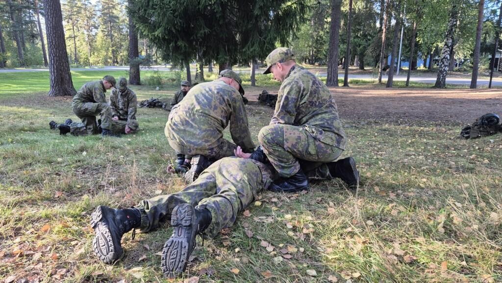 Kaksi sotilaspoliisia paketoimassa kohdehenkilöä