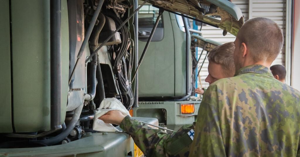 Kaksi henkilöä korjaamassa ajoneuvon moottoria