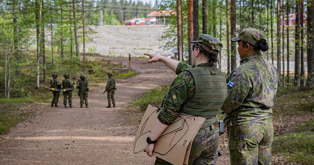 Naissotilas osoittaa kartta kädessä eteenpäin