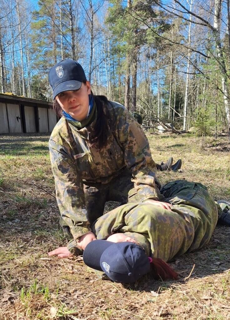 Tyttö ulkona ensiapurastilla, kääntämässä potilasta kylkiasentoon