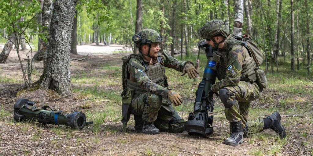 Kaksi maastopukuista miestä metsässä käsittelemässä panssarintorjuntaohjusta.