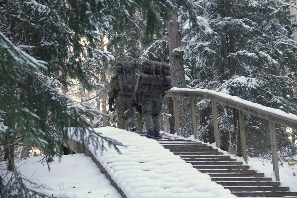 Kuntoportaat talvella, joissa kaksi henkilöä marssii maastopuvuissa ja reput selässä.