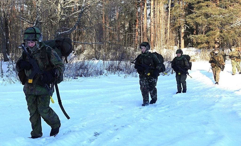 Naiset marssivat ulkona pakkasessa.