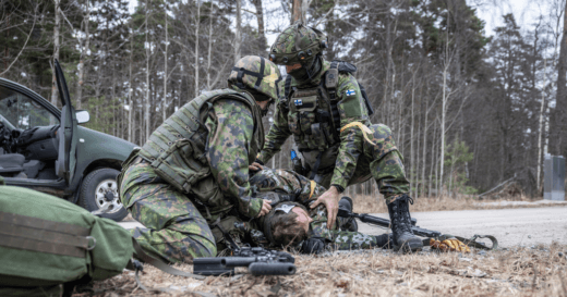Kaksi sotilasta hoitaa kolmatta kenttälääkinnän harjoituksessa