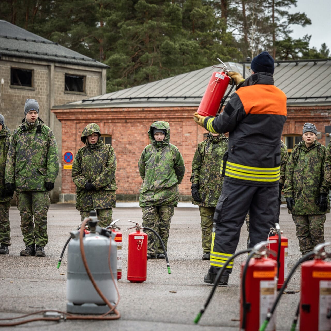 Henkilö kouluttaa ryhmää sammuttimen käytössä