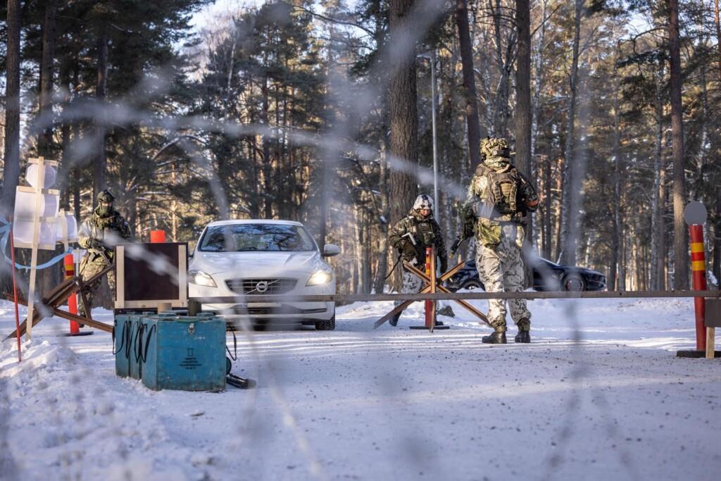 Sotilaita ja auto talvisessa maisemassa