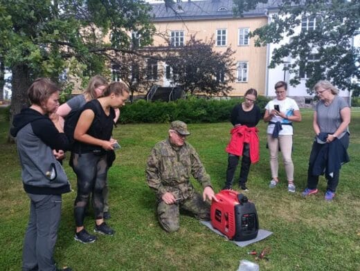 Ihmisiä nurmikolla tarkastelemassa aggregaattia