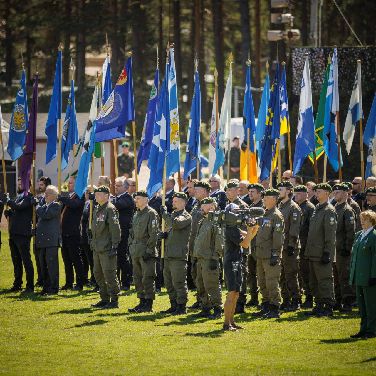 Uniformupukuisia henkilöitä Suomen lippujen kanssa