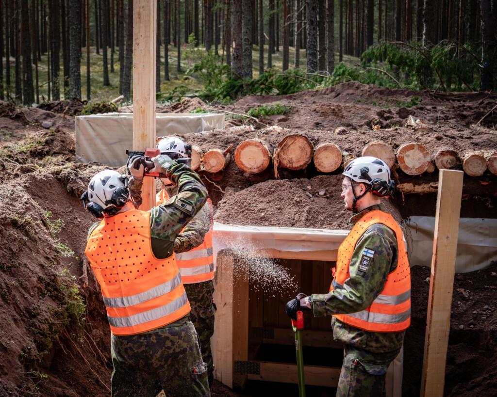 Huomioliiviset henkilöt rakentavat poteroa