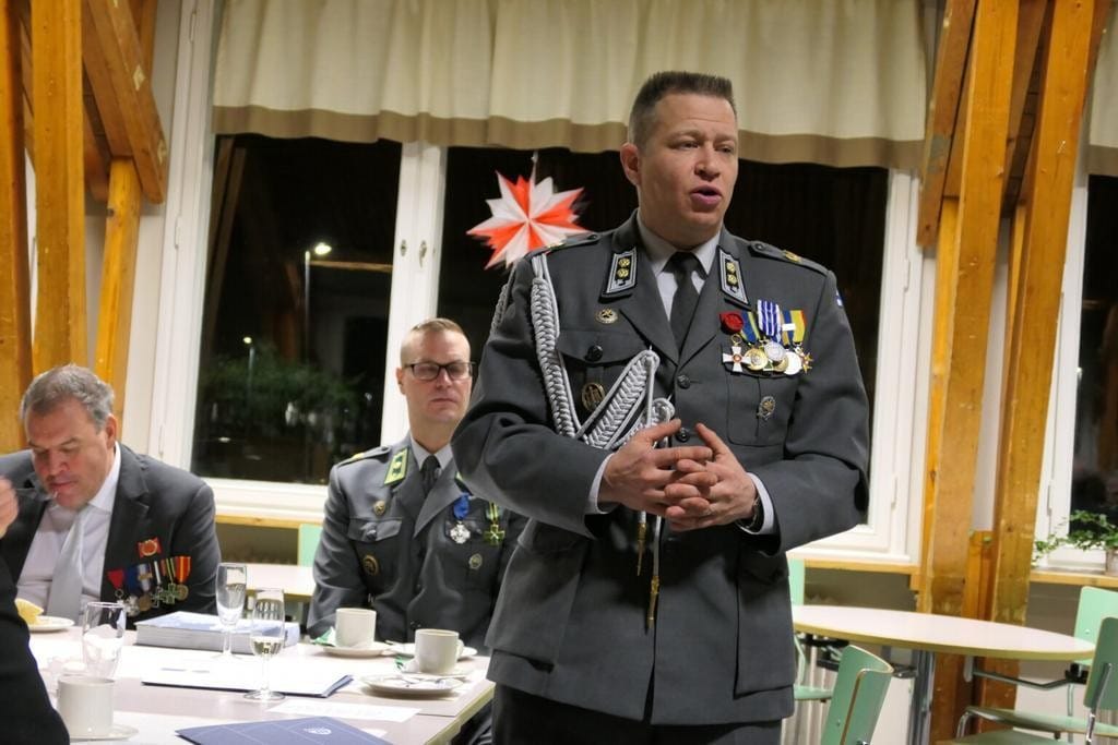Sotilaspuvussa oleva mies puhuu yleisölle