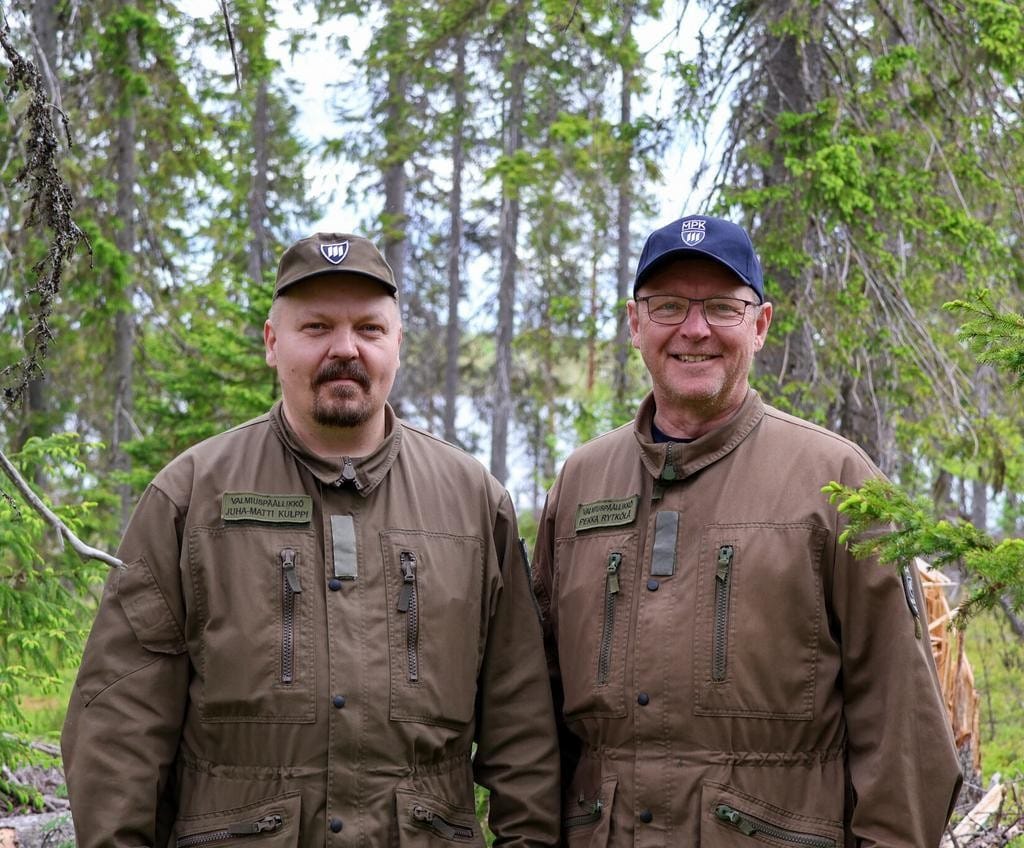 Kaksi sotilaspukuista miestä metsässä