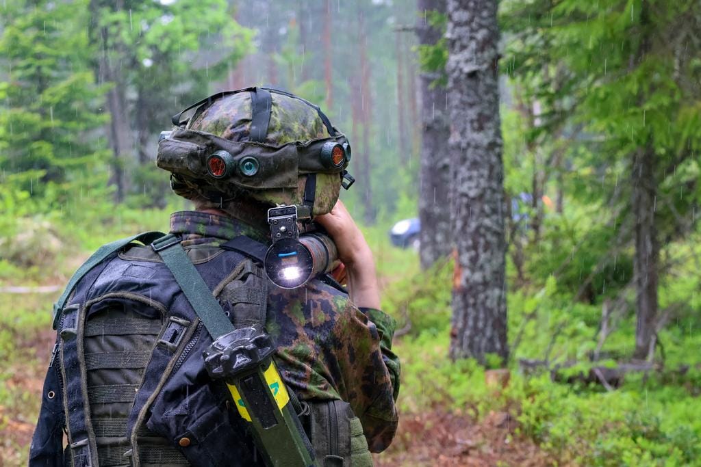 Sotilasvarusteinen henkilö metsässä