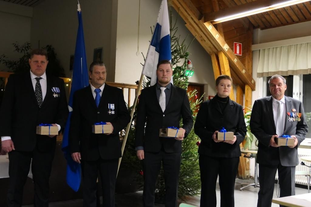 Ihmisiä juhlapuvuissa rivissä palkitsemistilaisuudessa.