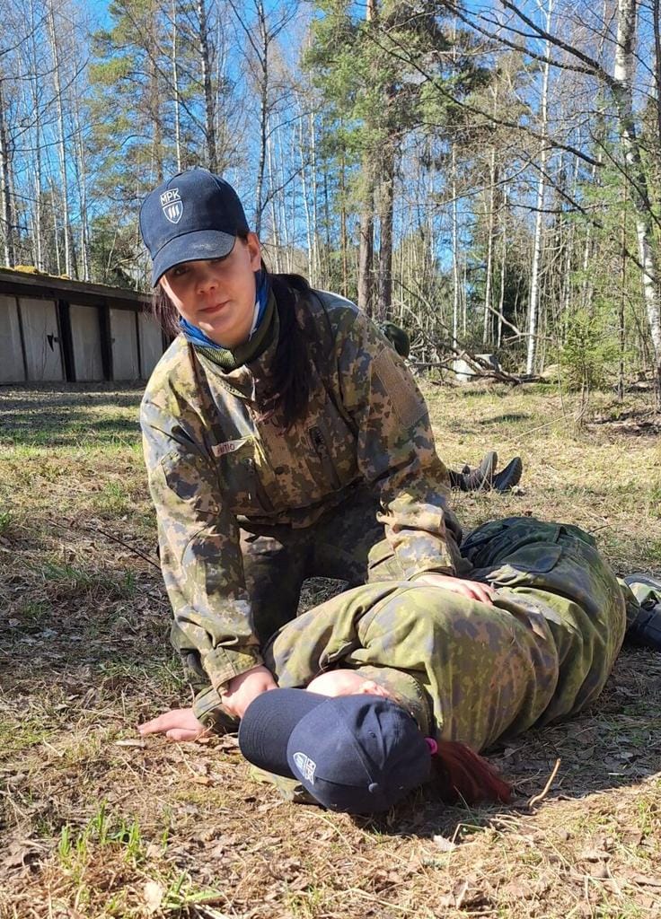 Tyttö ulkona ensiapurastilla, kääntämässä potilasta kylkiasentoon