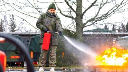 Tyttö harjoittelee tulen sammuttamista vaahtosammuttimella.