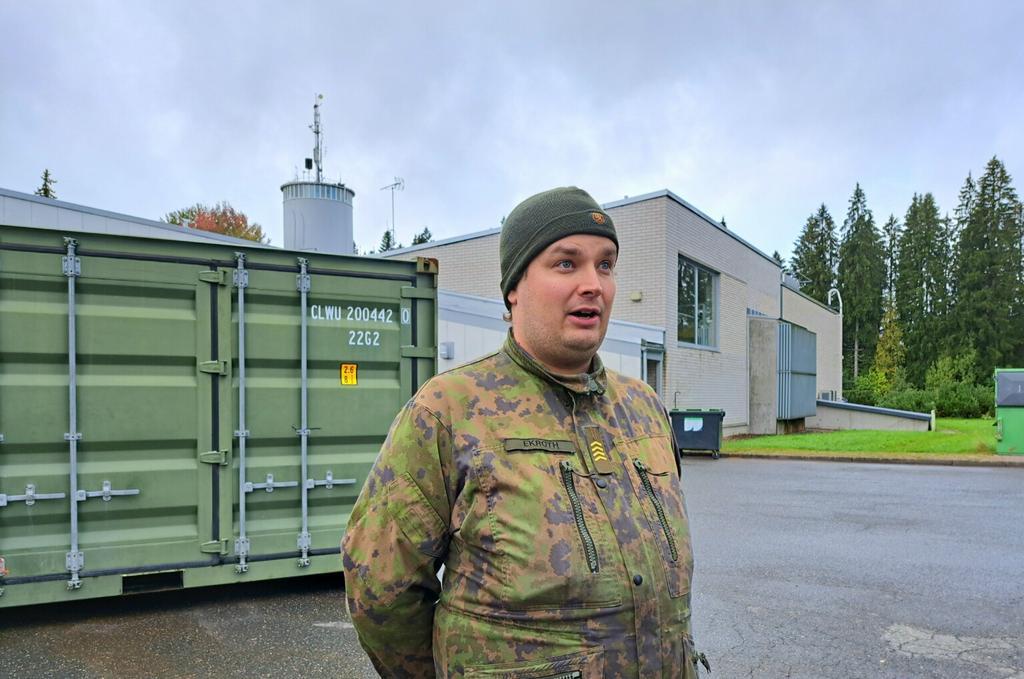 Sotilas seisoo keskellä kuvaa ja kertoo asiaansa