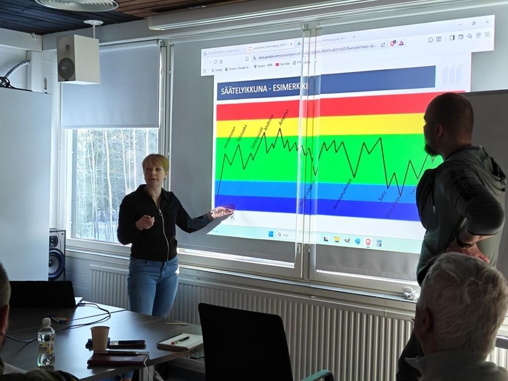 Naisluennoitsija näyttää valkokankaalle graafista esitystään.