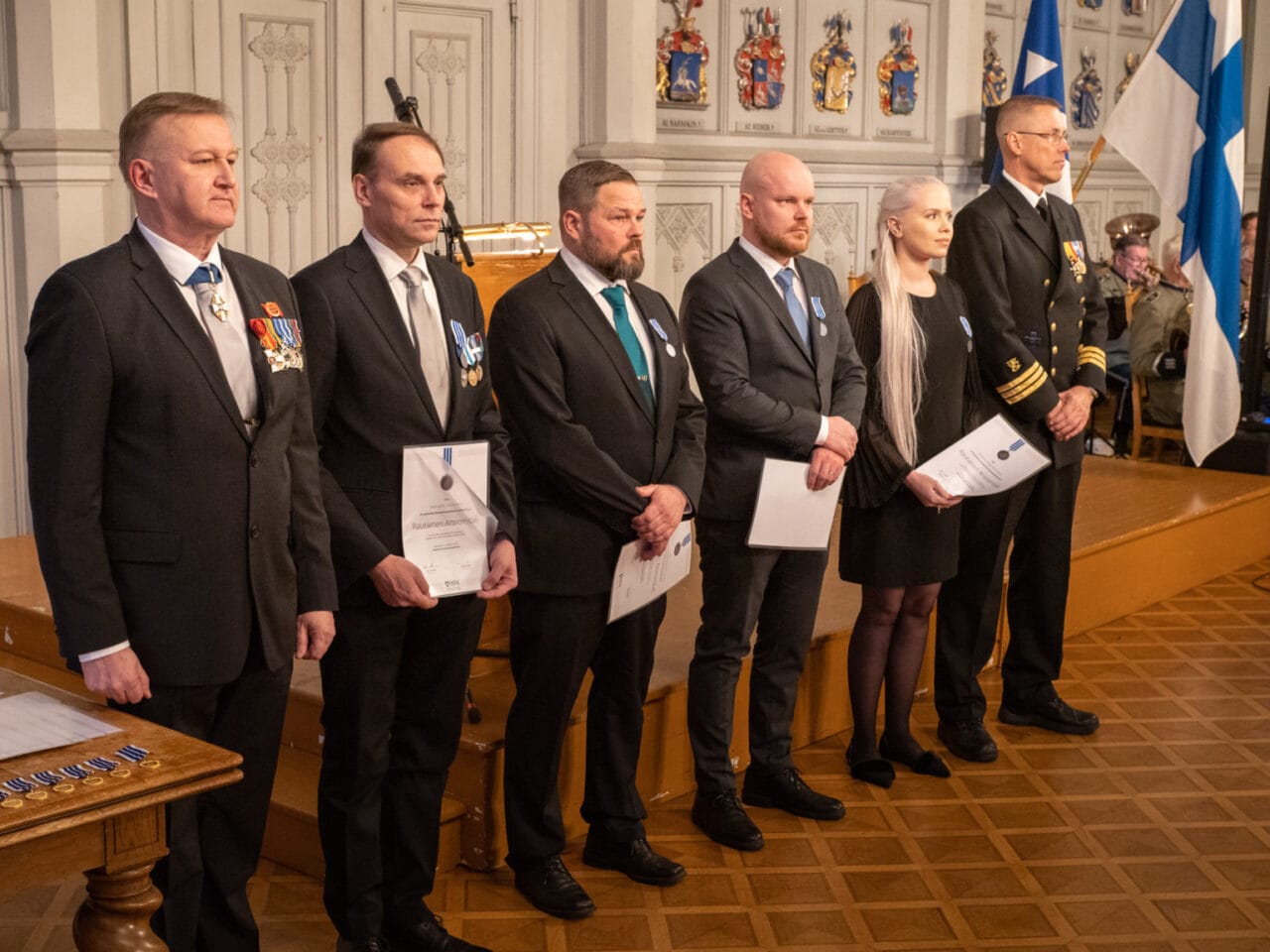 MPK:n rautaisen ansiomitalin saajat rivissä Ritarihuoneella.