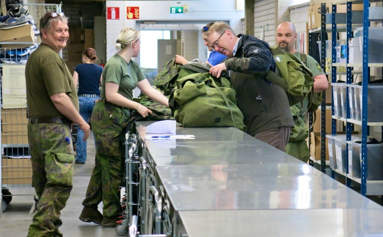 Ryhmä sotilasasuisia henkilöitä varastossa