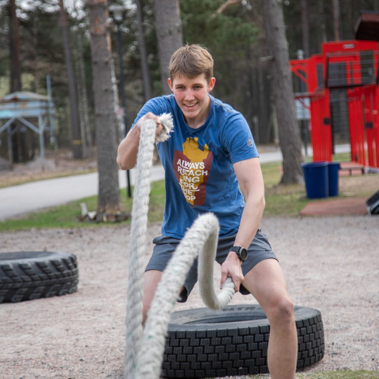 Nuori poika jumppaa kuntoköysillä