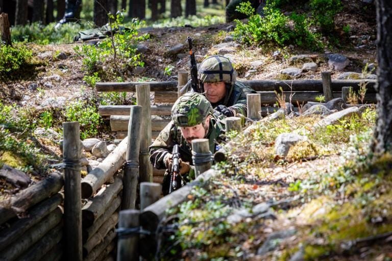 Kaksi taistelijaa etenee taisteluhaudassa