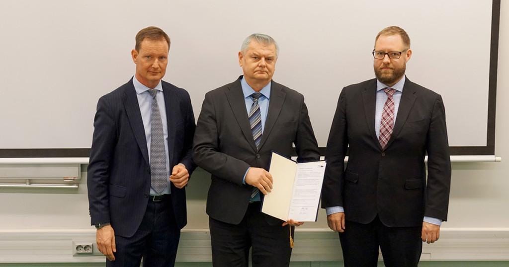 Kolme MPK:n kyberkouluttajien edustajaa Urlus-säätiön adressikannen kanssa.