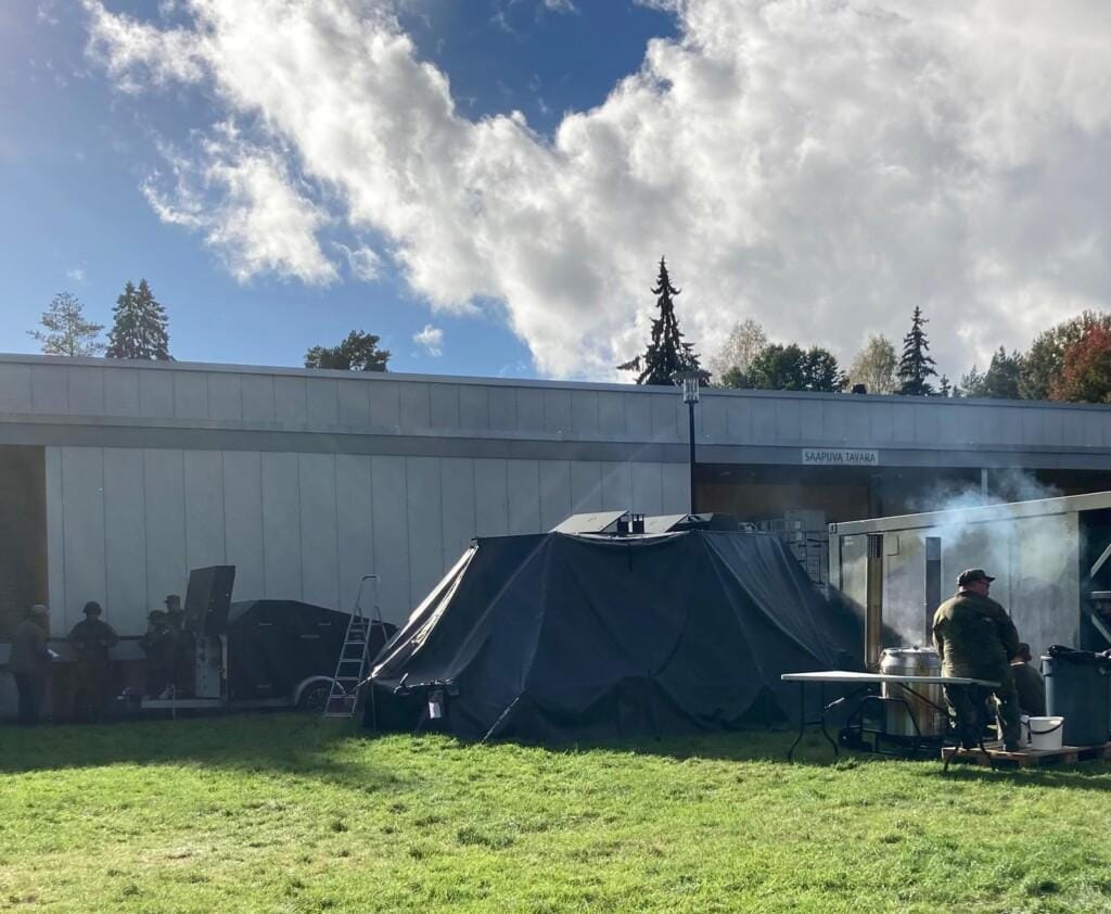 Kuvassa näkyy kenttämuonituskurssin puolijoukkueteltta. Kamiinan piipusta nousee savua.