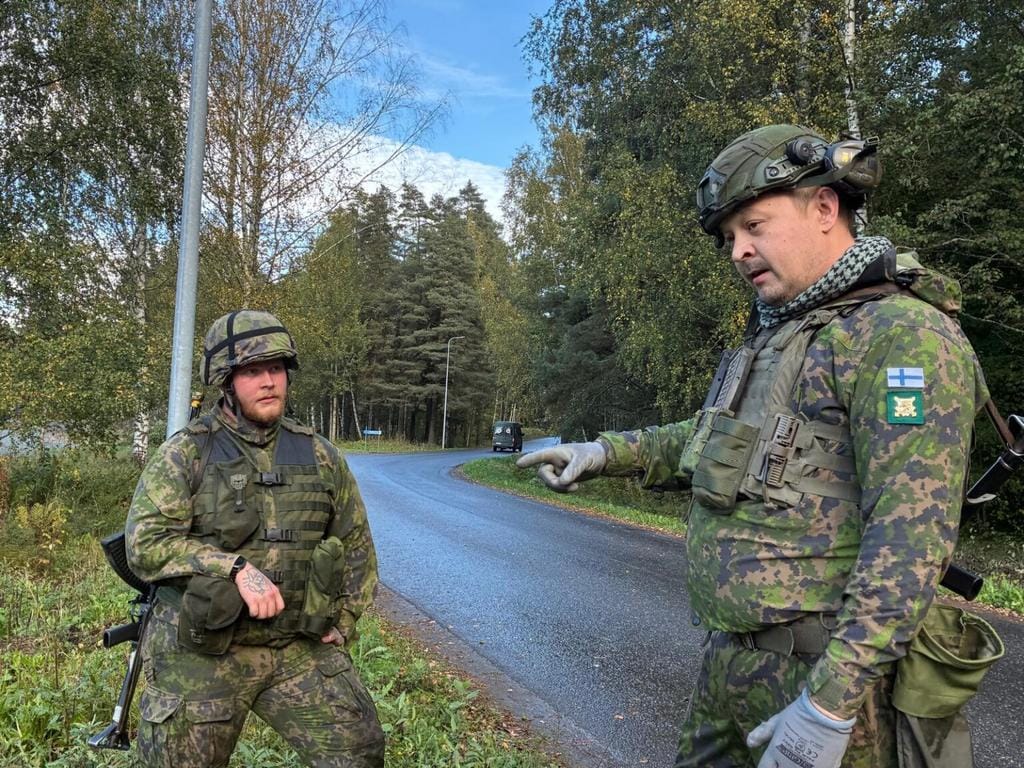 Kuvassa on maastopukuisia miehiä.