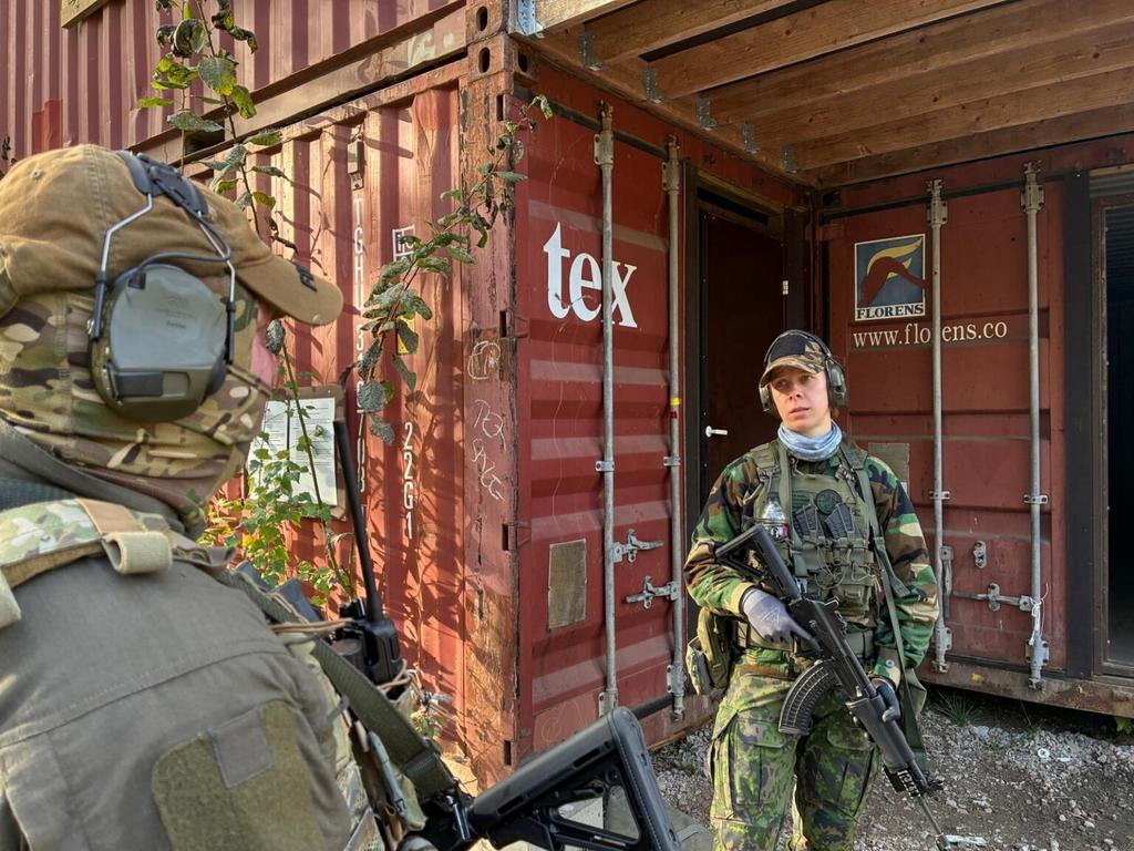 Kaksi henkilöä kontin edustalla