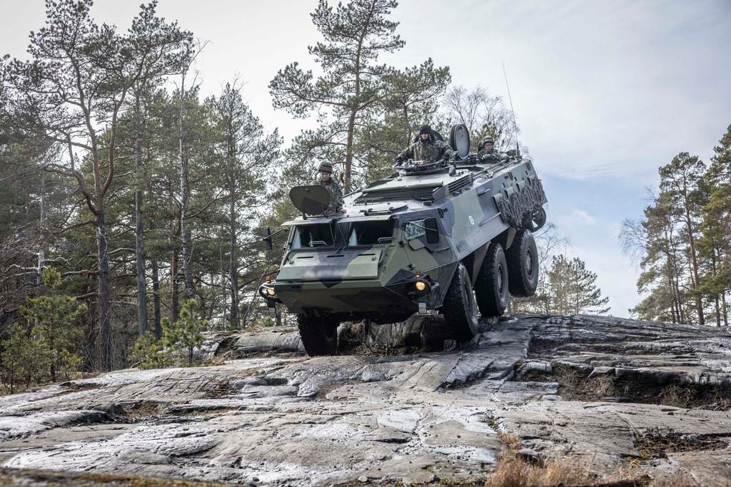 Puolustusvoimien ajoneuvo ylittää kallioista metsärinnettä