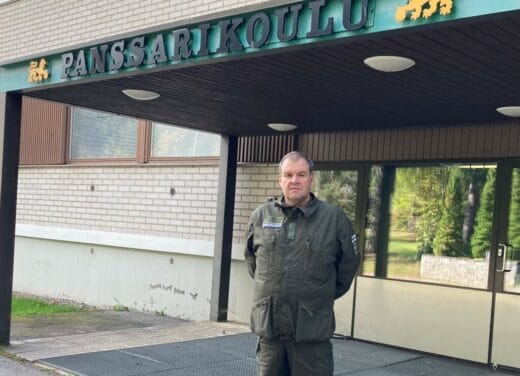 Mies seisoo Panssarikoulun sisäänkäynnin edessä