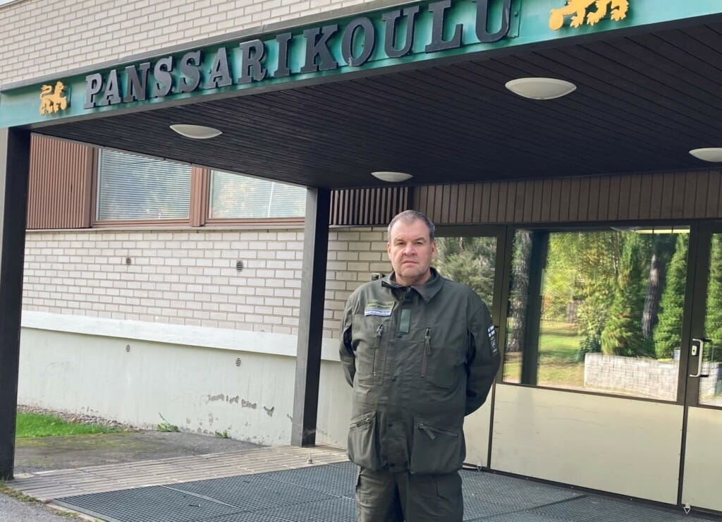 Mies seisoo Panssarikoulun sisäänkäynnin edessä
