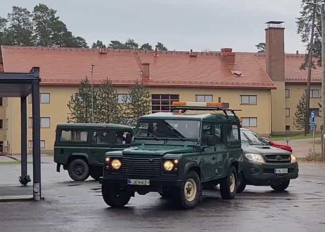Kolme autoa jonossa saapumassa talon etuovelle