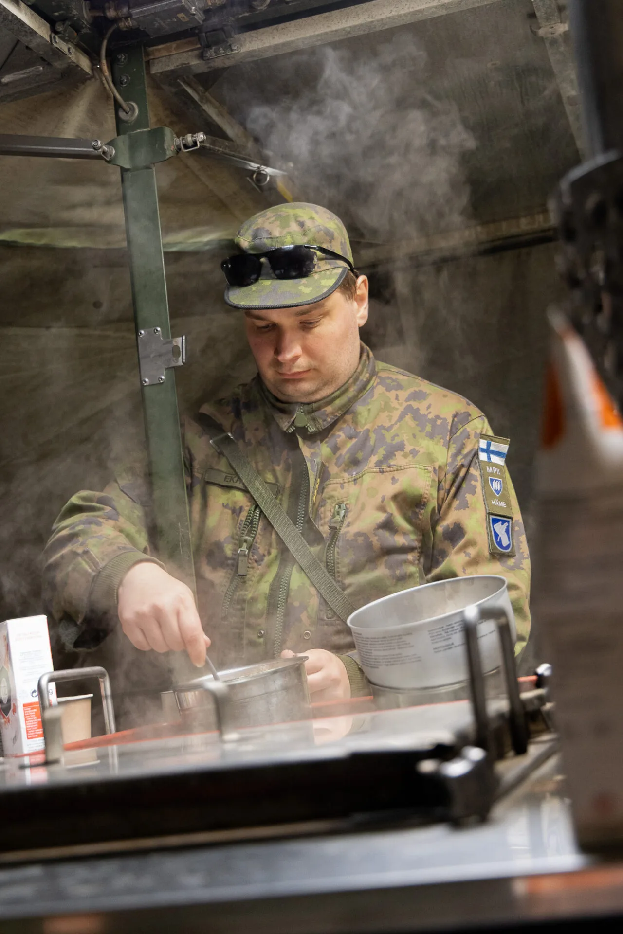 Mies kokkaa ruokaa teltassa