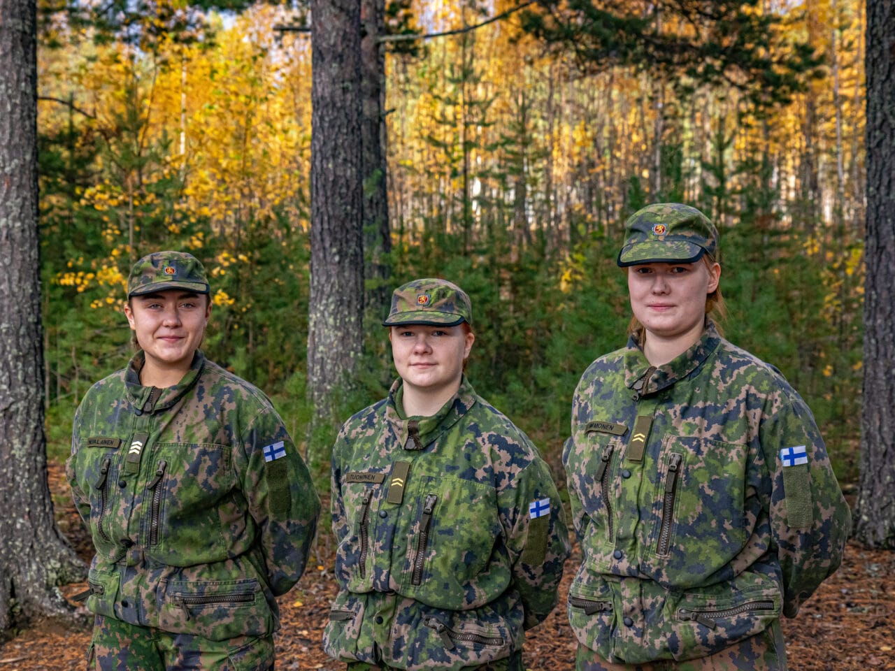 Kuvassa kolme maastopukuista naista, vasemmalta alkaen Roosa Nevalainen, Katri Tuononen ja Roosa Immonen. Kaikki katsovat kameraan ja hieman hymyilevät. Taustalla syksyinen metsä.