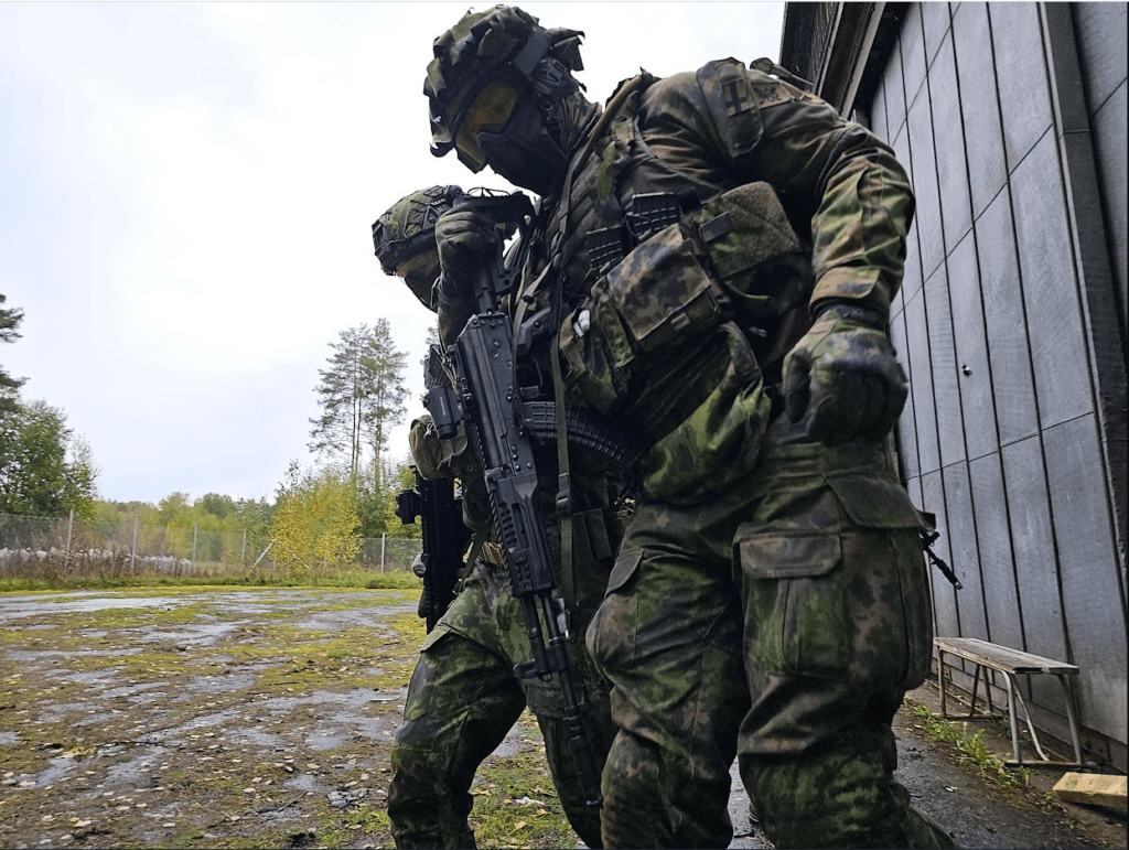 Kaksi henkilöä sotilasasuissa parakin edessä