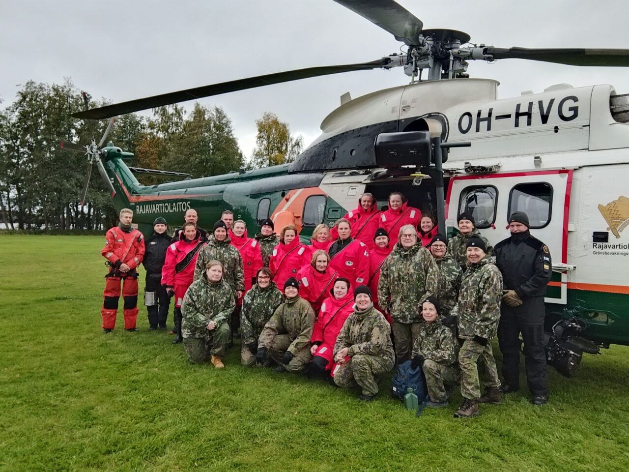 Kurssilaiset kokoontuneet kuvattavaksi Rajavartiolaitoksen helikopterin eteen
